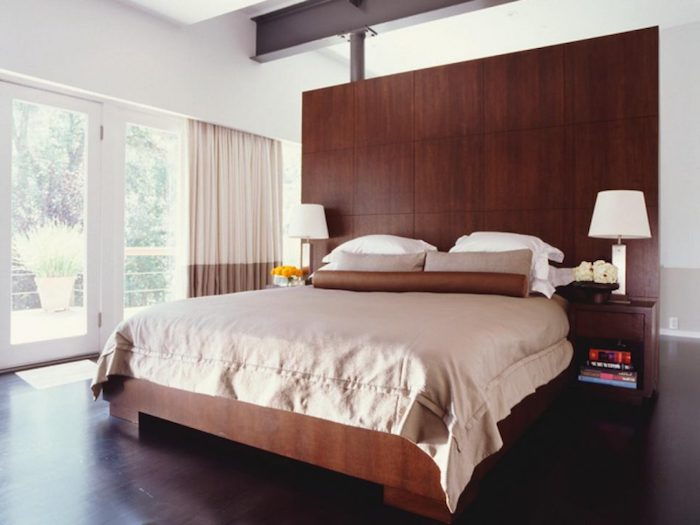 büyük bir yatak odası, kahverengi renkli genç oda, çok sayıda ahşap ve iki simetrik lamba