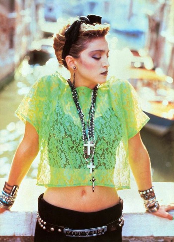 Yeşil tül bluz, siyah hairband, siyah pantolon ve birçok bilezik ile 80'lerde Madonna