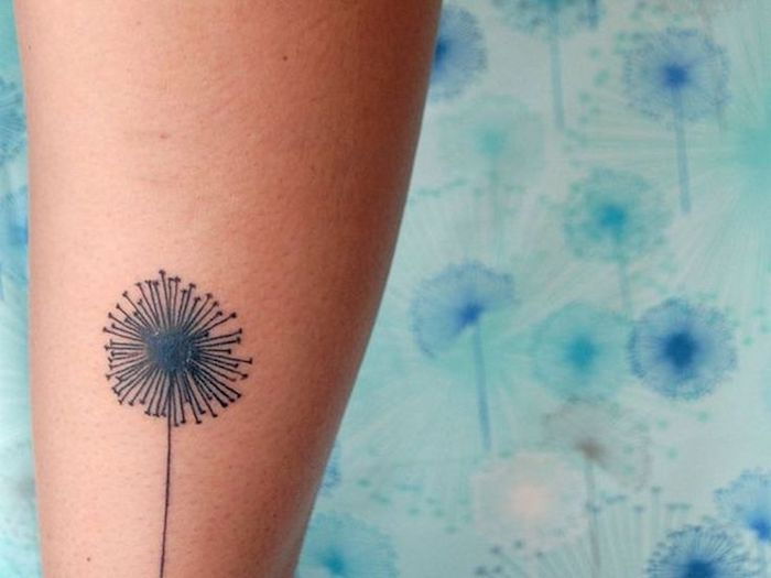små tatueringar kvinnor, svart maskros på benet, blomma tatuering