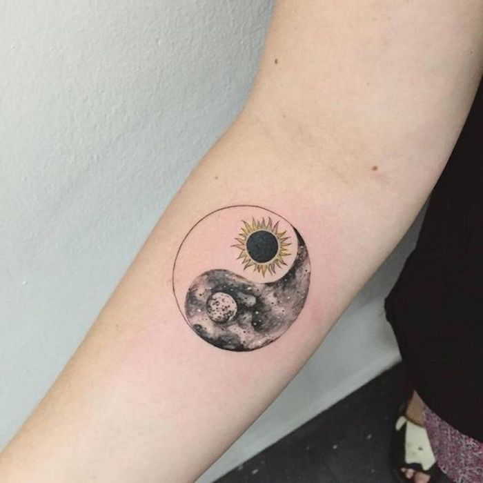 Tatuagem Yin-Yang no braço de uma mulher, sol e lua, preto e branco