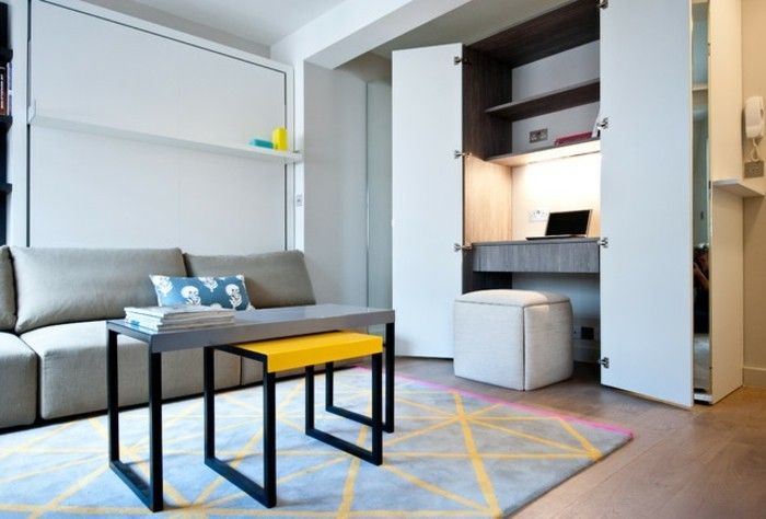 liten leilighet-set-innebygd skrivebord bygde-hyller-garderobe-mønster teppe-sofa-grå