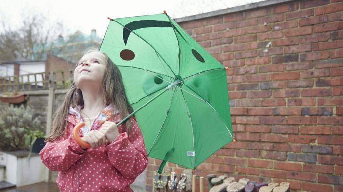 Dia chuvoso Menina do guarda-chuva da criança verde