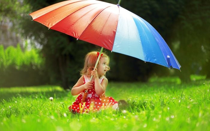 Menina na grama com grande guarda-chuva