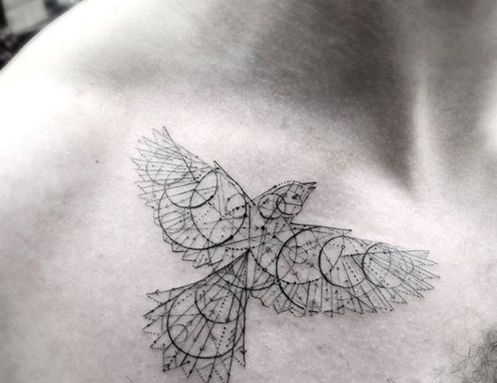 Tatuagem de pássaro com muitos círculos e espirais, muitos triângulos e linhas