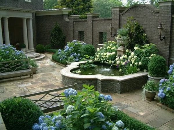 piscină elegantă în aer liber, flori colorate și pietre funerare în grădină