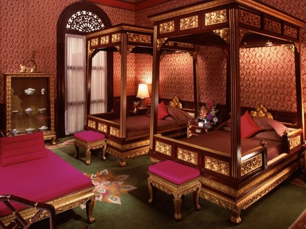 dve prostorni postelji s stolpci v luksuzni orientalski sobi