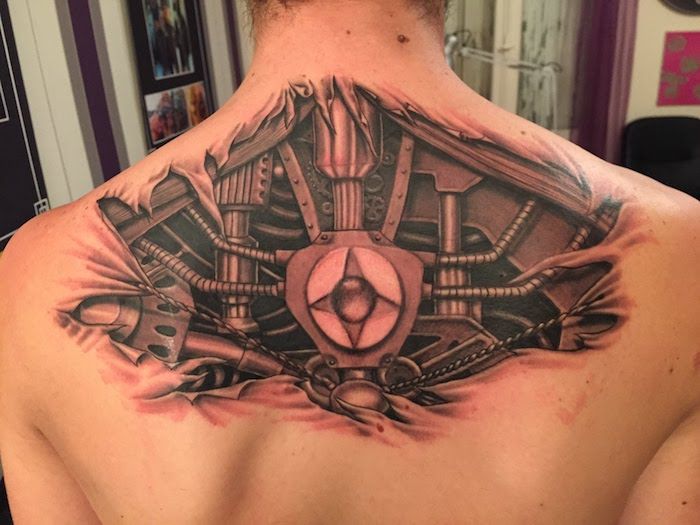 tatuaje motive bărbați, om cu tatuaj biomecanic pe spate