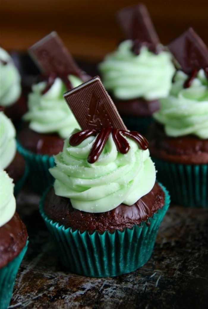 chocolade cupcake versierd met groene room en een stuk chocolade