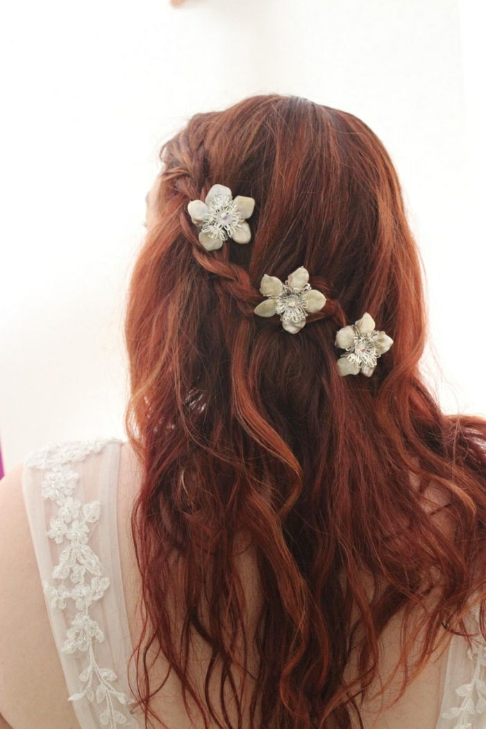 bir saç örgüsü ve çiçek saç gibi güzel bir beyaz takı ile örgülü kırmızı saç