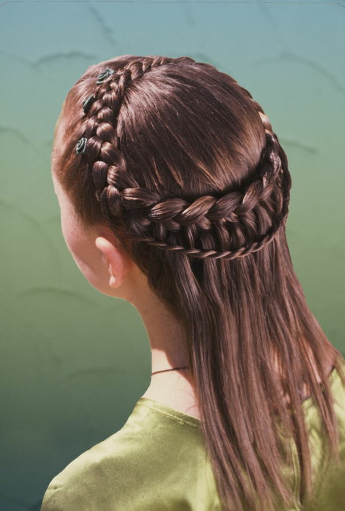 subtilus mergaičių vidutinio amžiaus šukuosena su rudais plaukais ir žaliomis gėlėmis kaip plaukų aksesuaras