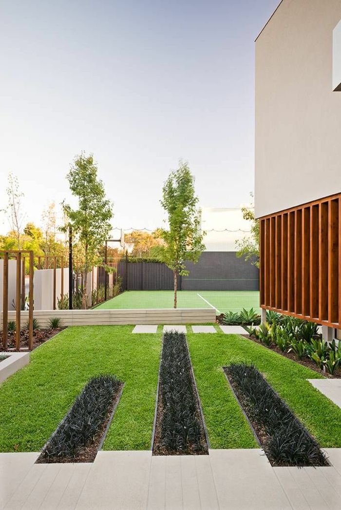 moderna yttergård med manicured gräsmattor och några träd så geometriska