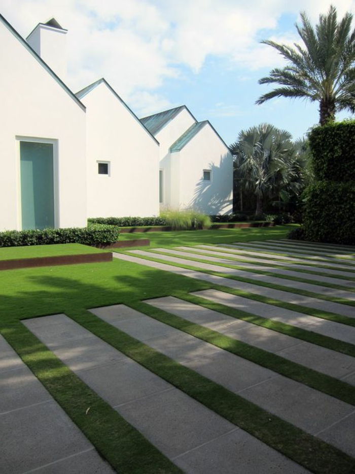 en minimalistisk modern trädgård med en geometriskt klippt gräsmatta