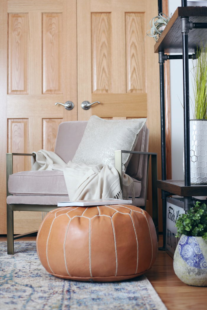 Mobili vintage, sgabello in pelle, comoda poltrona con cuscini decorativi, idee di interior design per il soggiorno