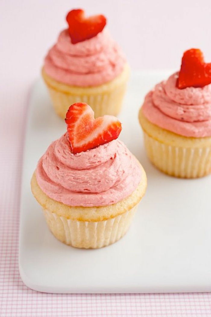 muffins versierd met roze room en aardbeienharten