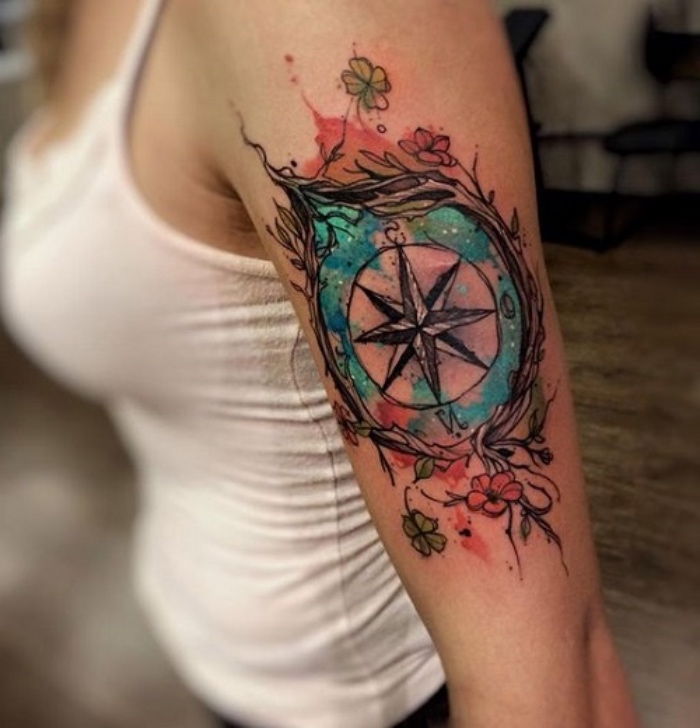 tai kompaktinio tatuiruotės moterims idėja - kompasas ir mažos žalios ir raudonos gėlės