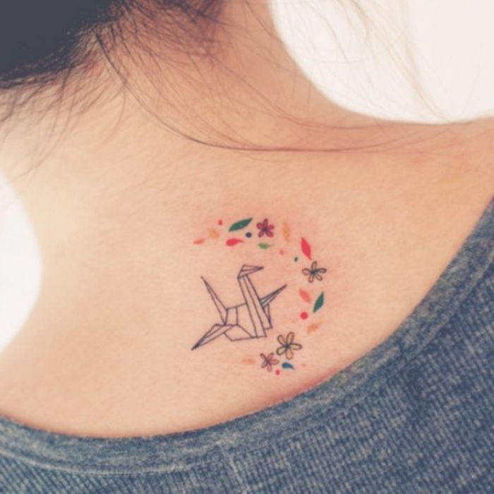 świetny pomysł na mały tatuaż origami na szyi młodej kobiety - oto latający ptak origami i wiele drobnych kwiatów