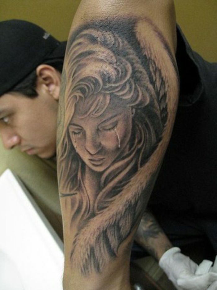 smutna i płacząca kobieta z dużymi anielskimi skrzydłami z białymi piórami - pomysł na anioła tatuażu dla mężczyzn