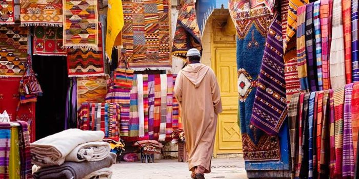 moški v lahkih oblačilih na trgu Agadir za orientalske tkanine, odeje in zavese