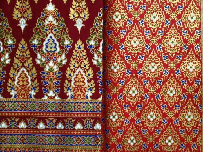 Tkanine z različnimi odtisi v rdečih tonih z modro, rumeno in zeleno oblogo