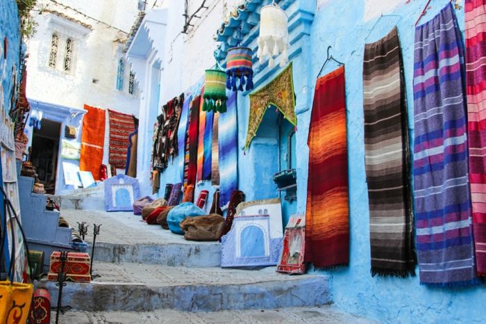 Modro mesto v Maroku, ulica s stopnicami - maroški trg za okraske in tkanine, šali in prevleke za blazine, majhne lesene dekorativne škatle in orientalski freske
