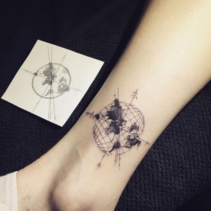 Här visar vi dig en idé för en tatuering på benet med en svart kompass med jord, planeter och svarta pilar