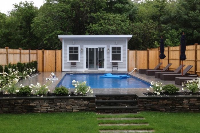ett litet hus med en stor swimmingpool framför - moderna yttergård
