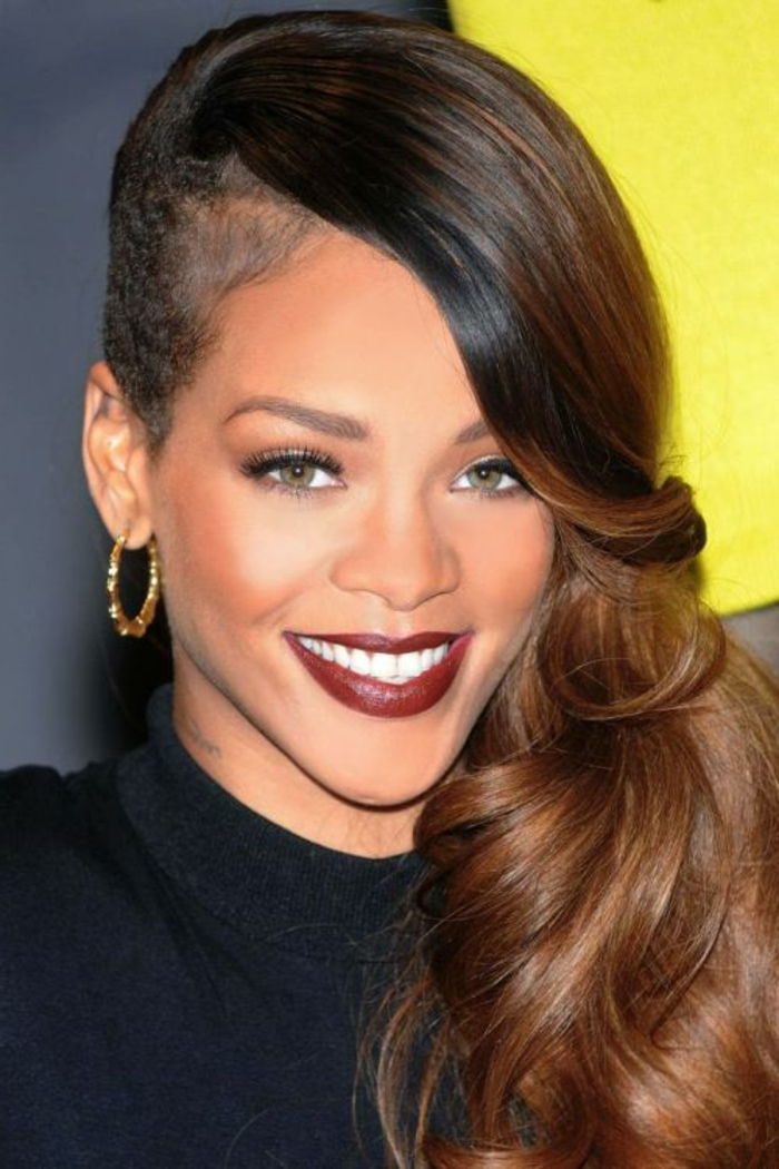 Sottosquadro con lunghi capelli castani su un lato, rossetto rosso e orecchini in oro Immagini di Rihanna