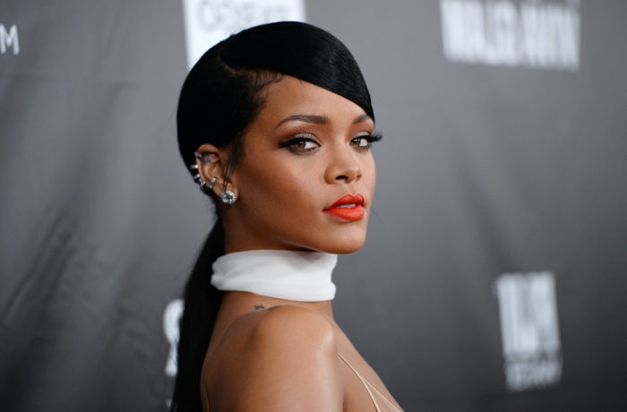 Rossetto rosso e sciarpa bianca, capelli neri e orecchini in argento - foto di Rihanna