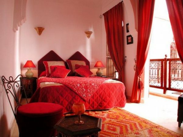 velika postelja v spalnici z rdečimi barvnimi shemami
