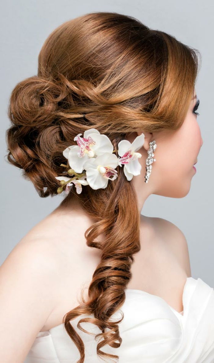 Hairstyles za dolge lase z velikimi skakačami, brezplačnim ponomijem in belo orhidejo kot pripomočkom za lase