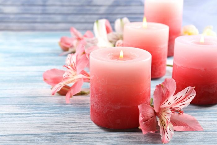 Gražios žvakės su gėlėmis ant medinio fono