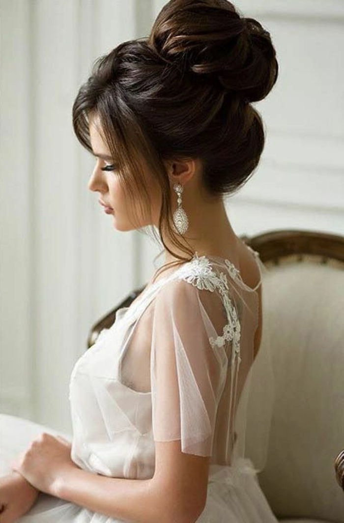 elegancka panna młoda w dniu ślubu z białą tiulową sukienką, kok z dużą objętością, swobodnie opadający kucyk