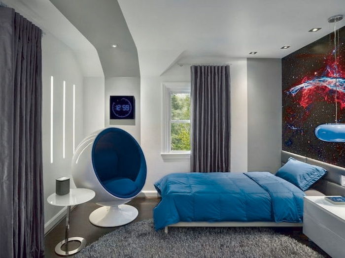 yuvarlak gri halı, mavi keten, beyaz masa ve modern bir koltuk - gençlik odası tasarımı