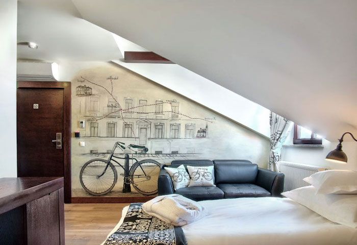 bisiklet duvar çıkartması, beyaz bir yatak, laminat zemin ile üst katta daire gençler için bir oda