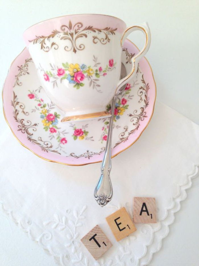 Xícara de chá chique gasto com padrão floral, rosa e branco