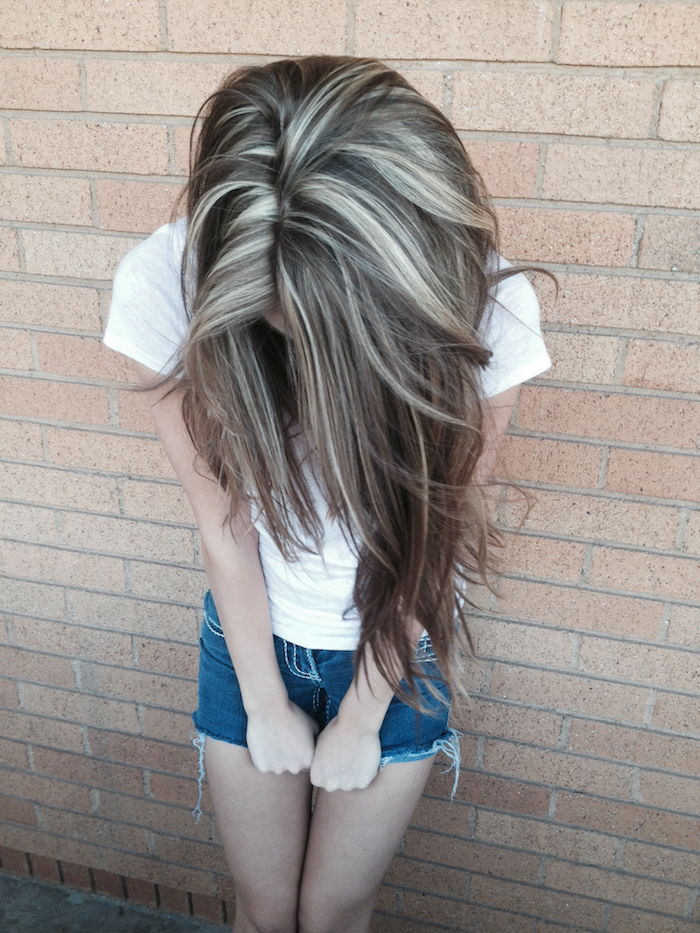 sidabriniai blondinai plaukai - mergaitė rodo savo plaukus, kuriuose yra sidabrinės blondinės akcentai