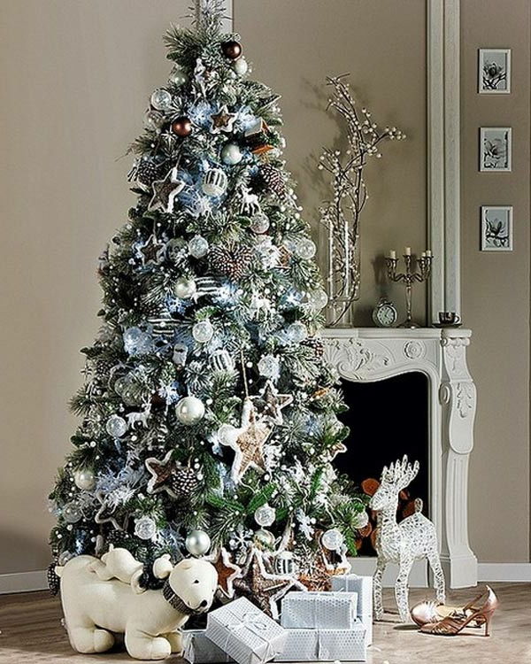białe świąteczne dekoracje - elegancki kominek i duża choinka obok niego