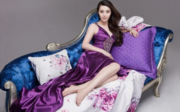 sofa-in-violetine-on-sofa-with-beautiful-woman-on-gray background