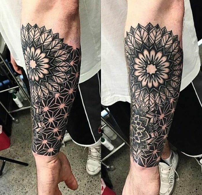 geometrisk tatuering på underarm, halvhårig tatuering på undersidan av en mans arm med en vit T-shirt, svart gymnastikbyxor och vita sportskor
