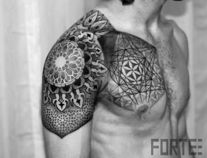 Gamla skolan och ny skolteknik förenar, geometrisk ornamental tatuering på axeln och på en ung mans kista med hår på bröstet