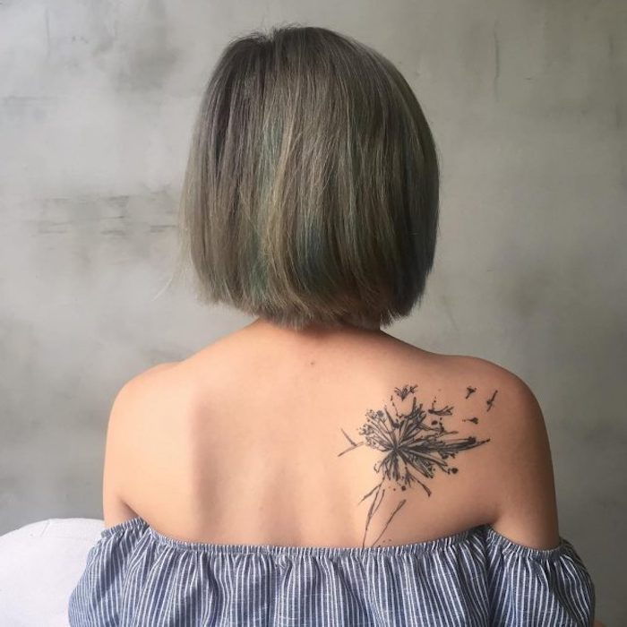 malé tetovacie motívy, žena s krátkymi sivými vlasmi a tetovanie na chrbte