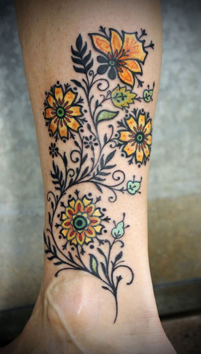 tatuiruotės motyvai moterims, kojų tatuiruotė, gėlės, geltonos ir juodos spalvos