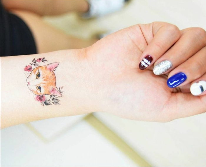 Ręka, palec, kolorowy lakier do paznokci, tatuaż kota na nadgarstku, mały kot, czerwone kwiaty