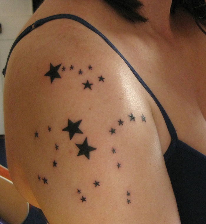 dövme yıldız kol - birçok küçük ve büyük siyah yıldız ile siyah dövme olan bir kadın
