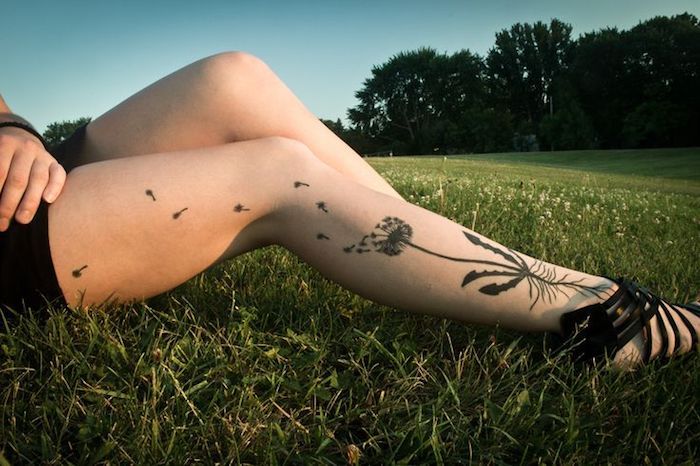 Lady med blowball tatuering på benet, svart och grå tatuering
