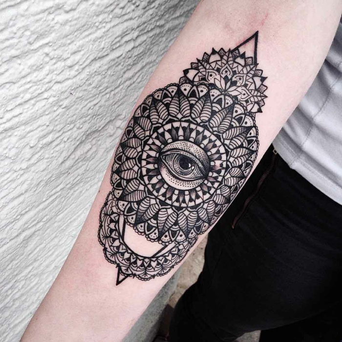 Lång tatueringsarm tatuering, två svarta tips på toppen och botten, en pyramid, många svarta linjer och ett trött öga