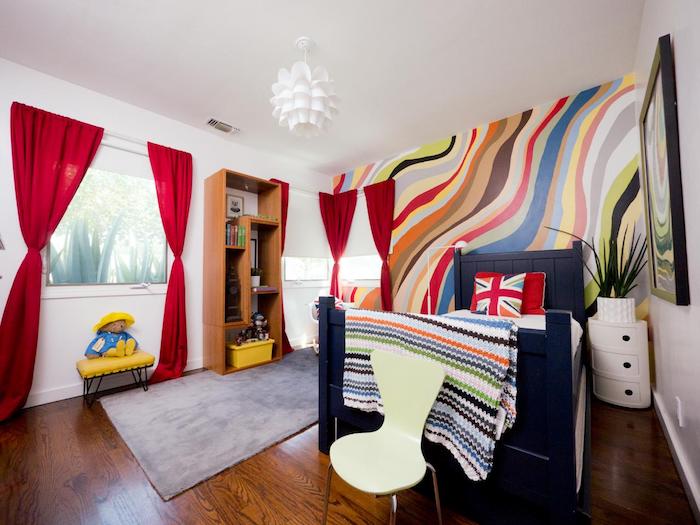 kırmızı perdeler, renkli duvar, desenli yastıklarla küçük yatak - güzel oda