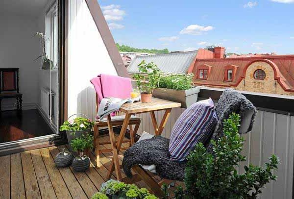 Medinė terasa su moderniu dizainu - žalieji augalai ir mesti pagalvės