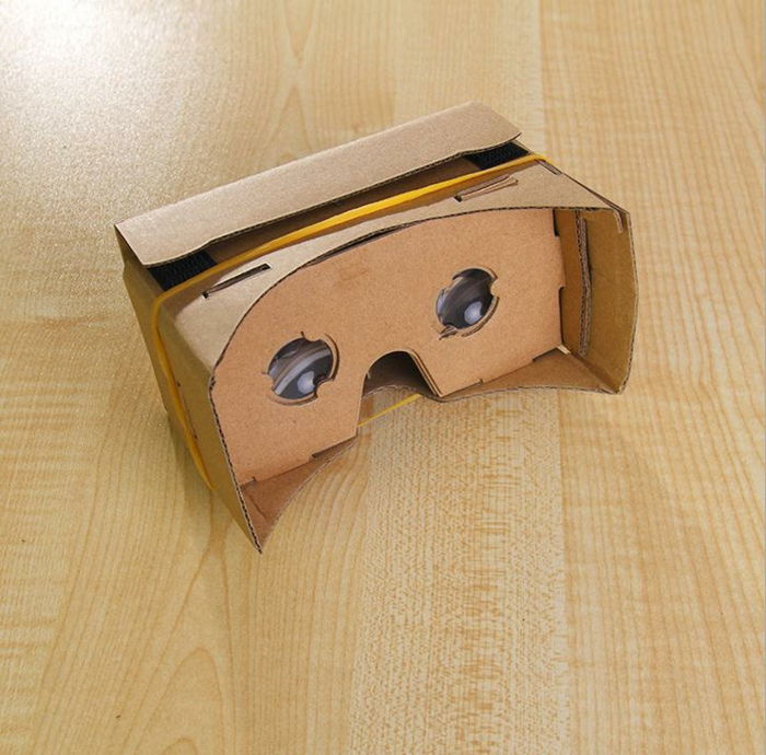 Tukaj so majhna samopritrjena očala virtualne resničnosti z dvema majhnim okularjem in rumenim gumijastim trakom
