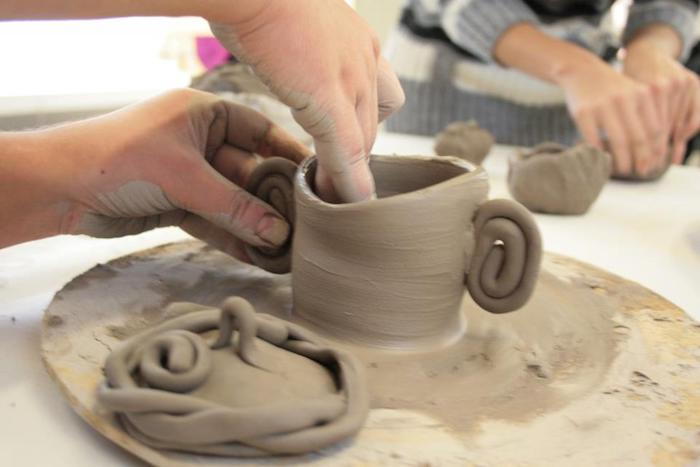 Le donne producono tazze di argilla grigia, ceramiche al giradischi